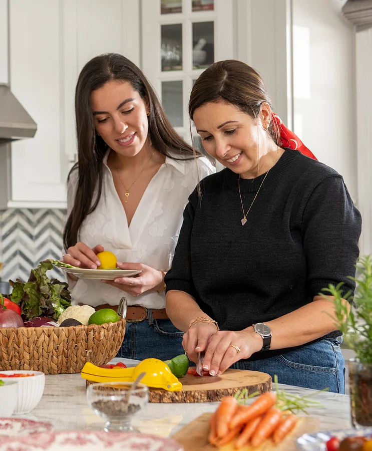 Two women preparing grain dishes in a kitchen